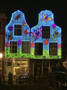 909496 Afbeelding van een lichtprojectie op de voorgevels van de panden Oudegracht 323 en 325 te Utrecht, in het kader ...